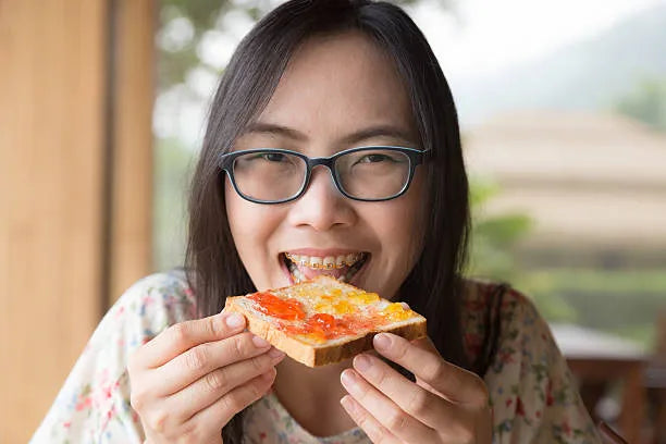 person eating soft toast with braces